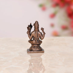 Copper deity statue rear view, detailed crown and arms, square base, 2 inch height