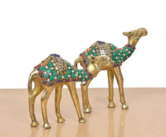 Brass camel figurine pair close-up, green paneling with multicolor dotted trim