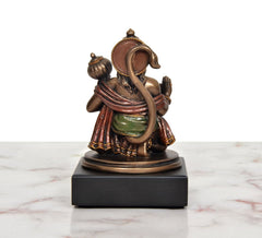 Resin Hanuman idol rear/side view, detailed drapery and crown, on dark square base.