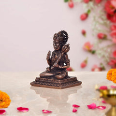 Copper Hanuman idol side view, seated pose with folded legs and raised hand