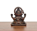 Sitting Ganesha brass idol, back view with circular halo and decorative arms
