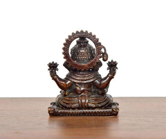 Sitting Ganesha brass idol, back view with circular halo and decorative arms