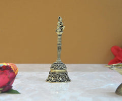 Brass pooja bell featuring Hanuman figure above carved stem and patterned skirt