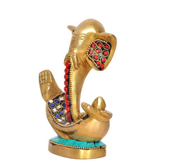 Close view of brass Ganesha idol with red pendant beads, jeweled arch panels, turquoise base