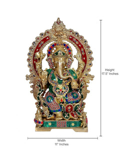 Brass Ganesh idol with ornate halo arch and colorful gem patterns on clothing