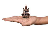 Copper Lakshmi idol statue held in hand for scale, seated on lotus base
