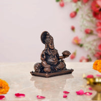 Copper Kuber idol statue, seated holding a small bowl, side angle on base