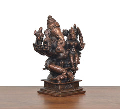 Copper Lord Ganesha statue viewed from angle, seated with Riddhi, carved base
