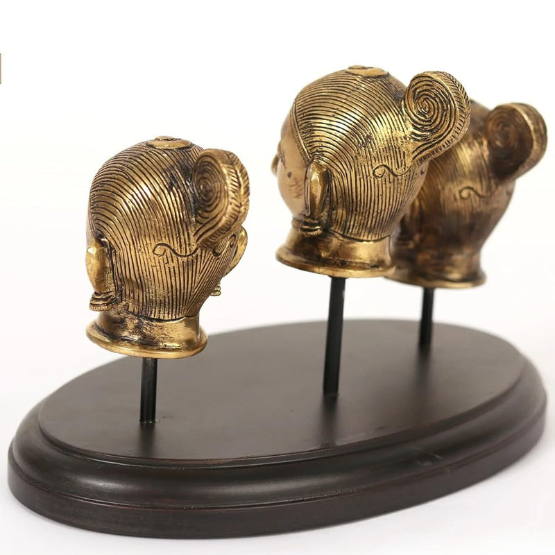 Two brass head idols back/side view on dark circular base with stems