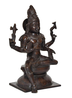 Lord Shiva idol statue, angled view showing detailed face and halo-like headdress, dark brass