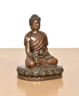 Gold-toned seated Buddha resin statue, side view, folded robe details and lotus base