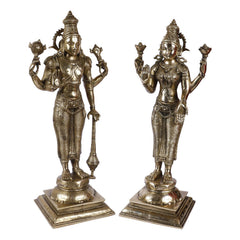 Two brass standing idols of Lakshmi and Vishnu, front-facing, ornate patterned garments