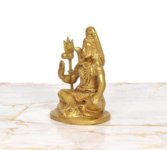 Lord Shiva brass sculpture side view, seated in blessing pose with raised hand and trident