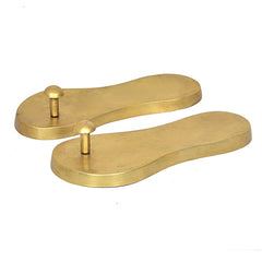 Brass khadau pooja paduka pair, lengthwise view, smooth base with two pegs