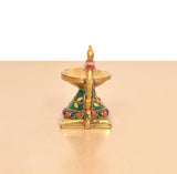 Brass peacock diya with hanging bell and wide gold-toned lamp bowl