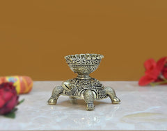 Brass tortoise diya statue, side view with ornate base detailing and patterned legs