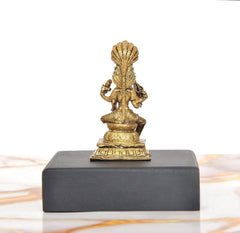 Back view of golden Mariamman Devi Durga idol on dark rectangular base
