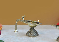 Brass aarti diya with lit wick, ornate arm and textured round pedestal base