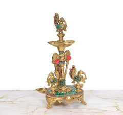 Brass peacock diya stand with multiple diya bowls around the central pillar, multicolor accents