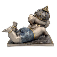 Baby Ganesha resin idol rear/side view, lying pose with raised feet on base