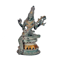 Saraswati brass statue playing veena, seated four-armed goddess figure, dark green finish