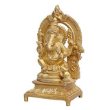 Golden brass Ganesh idol close-up with crown, halo, and raised hand on base