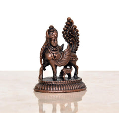 Rear view of copper Kamadhenu cow statue with wings, intricate detailing, circular base.