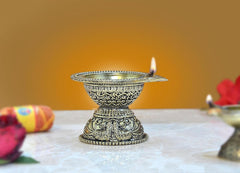 Brass aarti diya lamp with engraved bowl and stand, lit flame