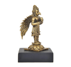 Back/side view of gold-tone Garuda figurine with wing details, on dark base