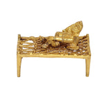 Brass Ganesha figure on charpai cot, angled view, compact 3.5-inch decor