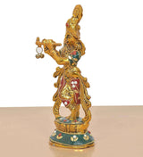 Metal Lord Krishna sculpture side view holding flute with small bells, decorative gold and red attire