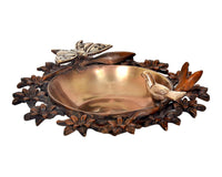 Brass urli bowl side view with butterfly and bird motifs on a textured floral base