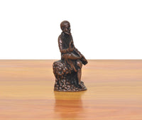 Shirdi Sai Baba statue angled view, seated with raised hand on textured base