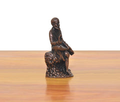 Shirdi Sai Baba statue angled view, seated with raised hand on textured base