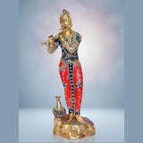 Krishna idol statue holding flute, blue and red patterned clothing with peacock at base