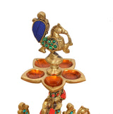 Close-up brass peacock oil lamp top with blue tail and five round oil cups