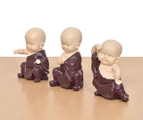 Purple resin monk Buddha figurines, seated, varying arm gestures, angled view