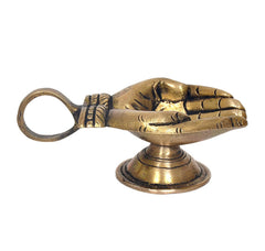 Brass hand-shaped diya oil-wick lamp, side view with handle loop and pedestal