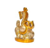 Brass Ganesha statue side view, curved trunk, gold crown and raised palm