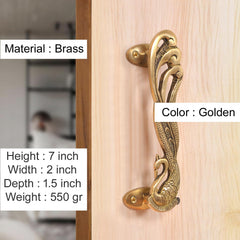 Golden brass peacock door handle pair, mounted on a light wood door