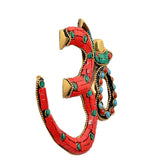 Brass OM wall hanging, side view: red mosaic arc with teal accents and beaded edges