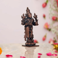 Copper Dhanvantari statue side view, four arms and detailed jewelry