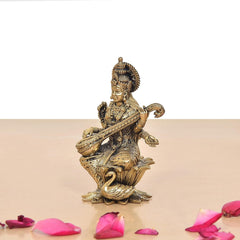 Brass Maa Saraswati statue in side view, seated on lotus with veena
