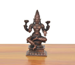Copper Lakshmi statue seated with four arms raised, detailed face and beaded crown.