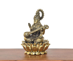 Brass Maa Saraswati statue side view, veena across legs on lotus base