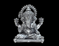 Brass Ganesha idol seated with four arms raised, detailed halo and pedestal.
