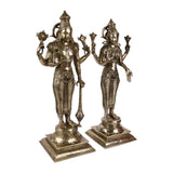 Front view of brass Lakshmi and Vishnu figurines with detailed jewelry, on raised bases