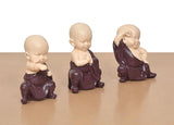 Purple resin monk Buddha figurines with prayer hands, seated, three-quarter angle