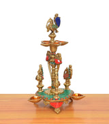 Brass peacock diya stand with central figure and three side diya bowls