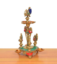 Brass peacock diya stand with central figure and three side diya bowls
